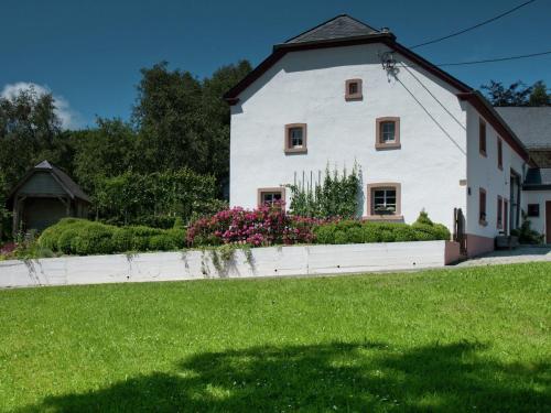 ビューリンゲンにあるModern Holiday Home in Bullange with Saunaの緑の庭のある大きな白い家