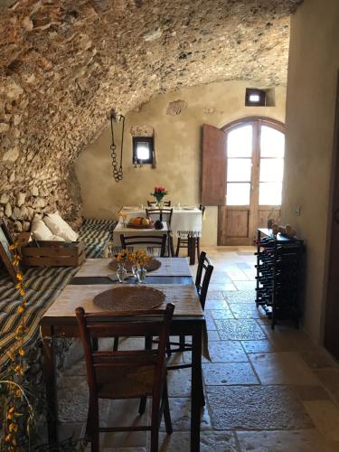 a dining room with a table and a stone wall at Charme in Perillis in Popoli