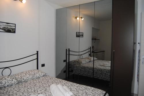 1 Schlafzimmer mit 2 Betten und einem Spiegel in der Unterkunft Casa da Greta in Lezzeno