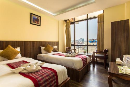 カトマンズにあるHotel Kathmandu Innのベッドが2つと窓があるホテルの部屋