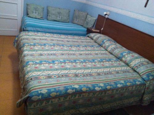 two beds in a room with a bedspread on them at Pensione Santachiara in Sanremo