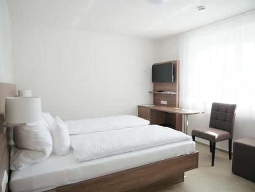 una camera con letto, scrivania e sedia di Hotel & Mühlenapartments a Gernsbach