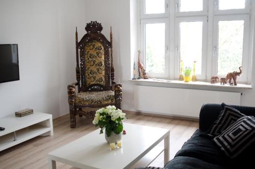 ein Wohnzimmer mit einem Sofa und einer Vase mit Blumen auf dem Tisch in der Unterkunft Schöne 3-Zimmer Wohnung im Herzen von Wuppertal in Wuppertal