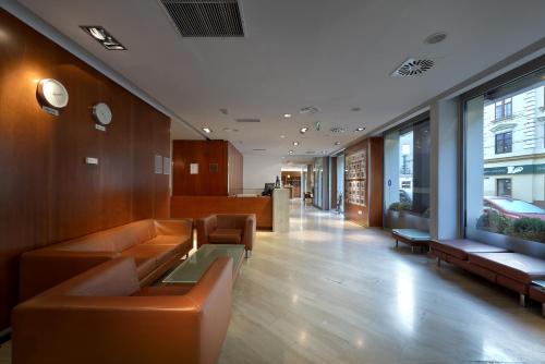 an office lobby with brown leather couches and tables at Exe Vienna in Vienna