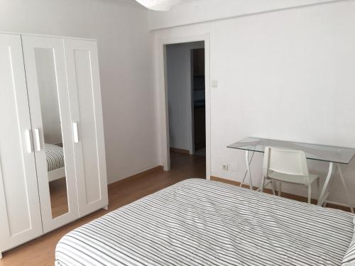 Apartamento Huesca en Paseo Ramón y Cajal في ويسكا: غرفة نوم بسرير ومكتب وطاولة