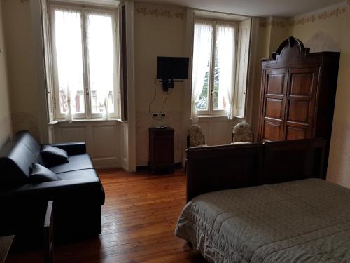a bedroom with a bed and a couch and windows at Alla Torretta in Bellagio