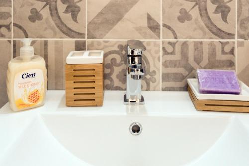 - un lavabo dans la salle de bains avec un distributeur de savon et une bouteille de savon dans l'établissement AMAZING 1 bedroom LOFT in NICE city centre seafront, à Nice