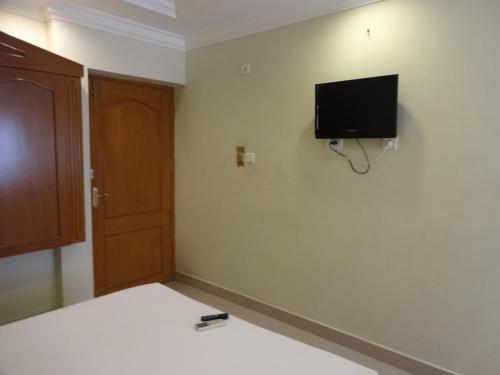 a bedroom with a bed and a tv on the wall at Hotel Susee Park in Tiruchchirāppalli