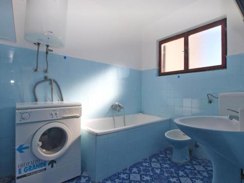 a blue bathroom with a washing machine and a sink at House Angela 1585 in Rakalj