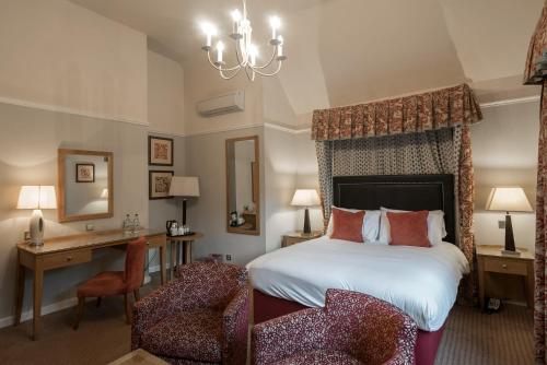 um quarto com uma cama, uma secretária e uma cadeira em Westmead Hotel Bar & Restaurant em Hopwood