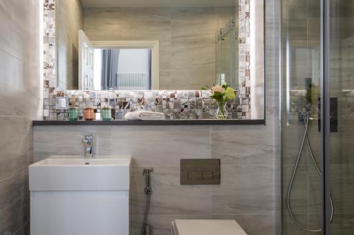 a bathroom with a shower and a sink and a mirror at Baker Street by Viridian Apartments in London