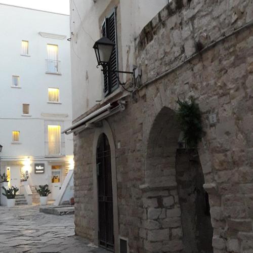 a building with a stone wall and a street at La Maison in Trani