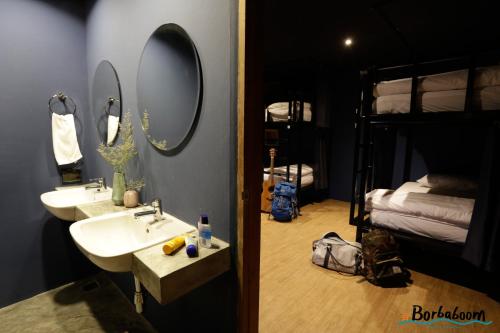 a bathroom with two sinks and a bunk bed at Borbaboom Phuket Poshtel & Hostel in Phuket Town