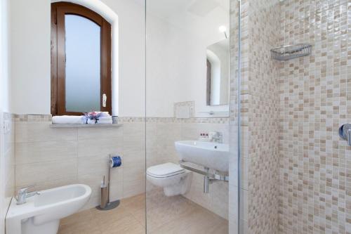 a bathroom with a sink and a toilet and a mirror at Villa Iolanda in Piano di Sorrento