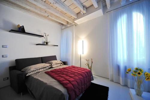 a bedroom with a bed with a red blanket at Venetian Apartments in Venice