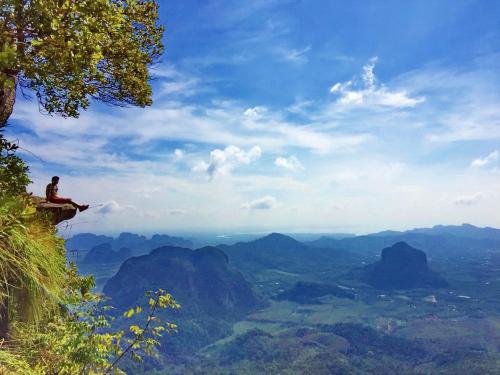 a man sitting on a ledge in the blue mountains at Krabi Home Resort in Tab Kaek Beach