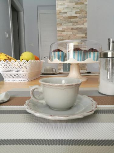 une tasse blanche et une assiette sur une table dans l'établissement B&B A casa dell'artista, à Casteldaccia