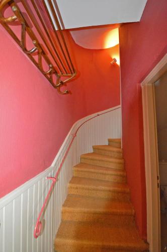 a stairway with red walls and a red wall at Mas Antonin in La Garde-Adhémar