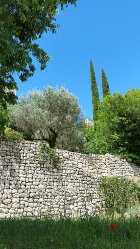 a stone wall with a tree on top of it at Mas Antonin in La Garde-Adhémar