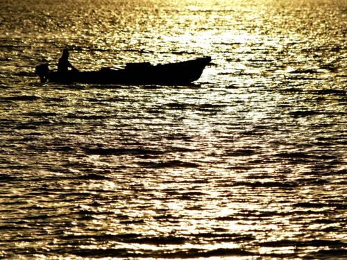 a man in a boat on the water at Pension Moon Villa in Onna