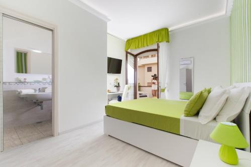 - une chambre avec un lit vert et blanc et une salle de bains dans l'établissement Villa Iolanda, à Piano di Sorrento
