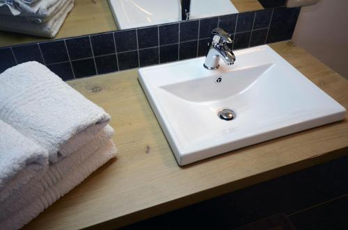a white sink in a bathroom with a towel at Hotel het Elsland in Wervik
