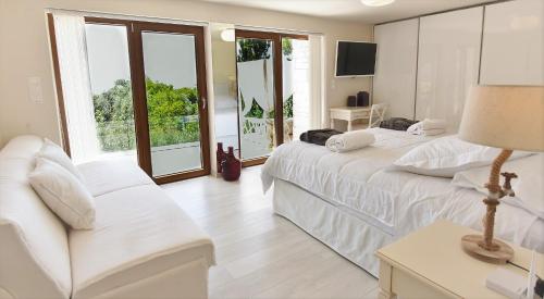 una camera da letto bianca con due letti e un divano di Villa Evangelia a Chania