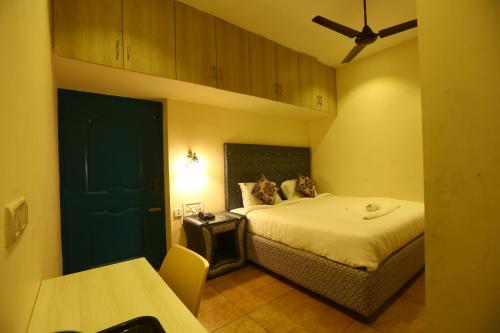 a small room with a bed and a table and a room at Zingle Stay Airport Hotel in Chennai