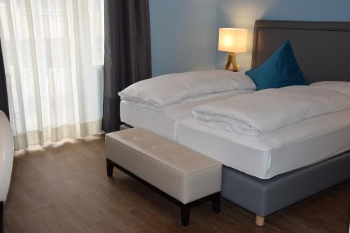 two twin beds in a room with a lamp at Atel Hotel Lasserhof in Salzburg