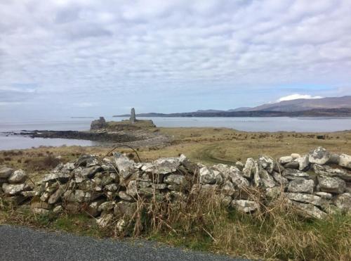 a stone wall next to a body of water at Cannon Cottage in St John's Point