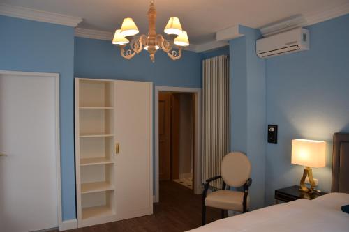 a bedroom with blue walls and a chandelier at Atel Hotel Lasserhof in Salzburg