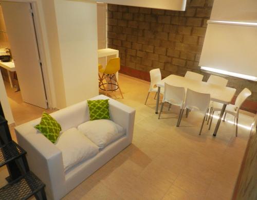 a living room with a couch and a table and chairs at Alta Patagonia Apart in Viedma