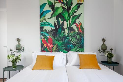 セビリアにあるApartamentos RG Suites Jardines de Murilloの白いベッド1台付きのベッドルーム1室(壁に絵画付)