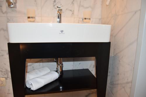 a white sink in a bathroom with towels at Atel Hotel Lasserhof in Salzburg