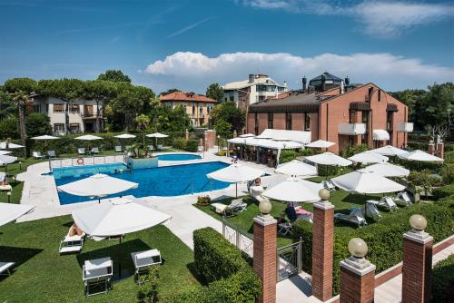 ein Resort mit einem Pool und Sonnenschirmen in der Unterkunft DB Villas Le Ville del Lido Resort in Lido di Venezia