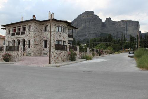 a stone building with a mountain in the background at Monastiri Guesthouse in Kalabaka