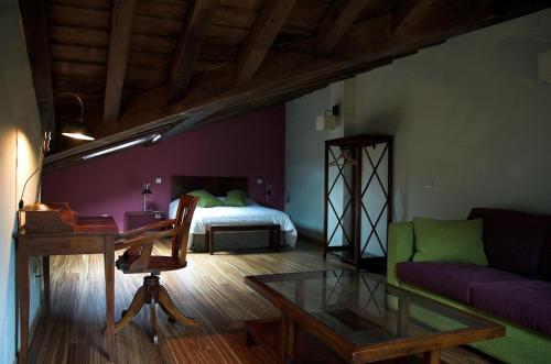 a living room with a desk and a bed at Estrella rural casa rural en la Sierra de Madrid in Buitrago del Lozoya