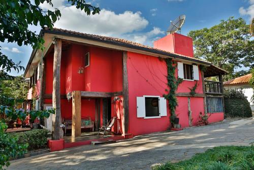 a red house with a cross on top of it at Solar dos Ipês in Serra do Cipo