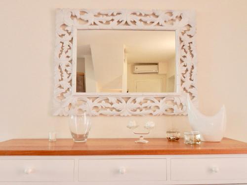a mirror on a white wall above a dresser at Villa Mare in Lido di Camaiore