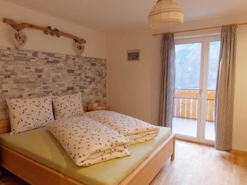 1 dormitorio con 1 cama con pared de ladrillo en Niederhof, en Parcines