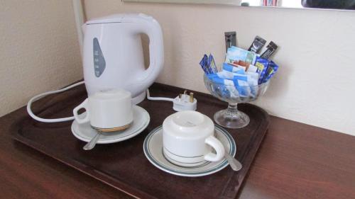 a counter with two cups and a tea pot on it at Diamond House in Rugby