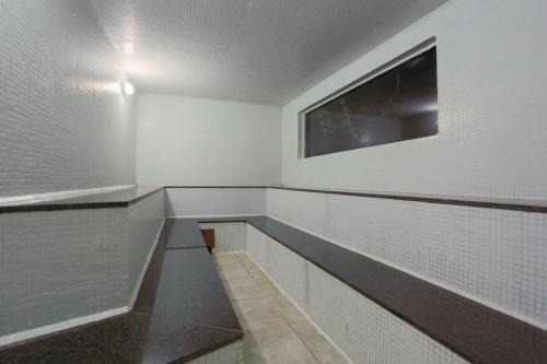 an empty bathroom with white walls and a window at Solar dos Ipês in Serra do Cipo
