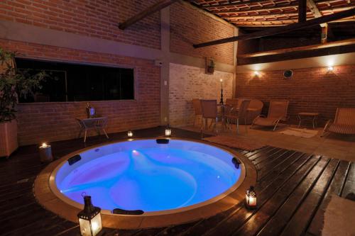 a large hot tub in a room with a table and chairs at Solar dos Ipês in Serra do Cipo