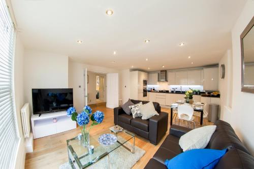 a living room with a couch and a table at Finchley Central - Luxury 2 bed ground floor apartment in Hendon