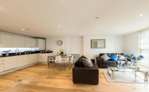 ein Wohnzimmer mit einem Sofa und einem Tisch in der Unterkunft Finchley Central - Luxury 2 bed ground floor apartment in Hendon