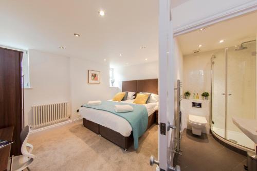 a bedroom with a bed and a bathroom at Finchley Central - Luxury 2 bed ground floor apartment in Hendon