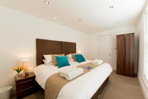 1 dormitorio con 1 cama blanca grande con almohadas azules en Finchley Central - Luxury 2 bed ground floor apartment, en Hendon
