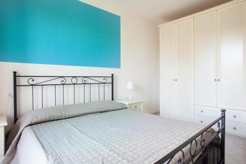 a bedroom with a bed and a blue wall at La Fonte degli Angeli Apartments in Suvereto