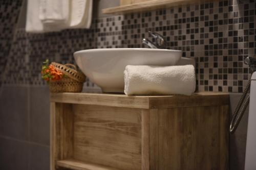 a bathroom sink sitting on a wooden stand with a towel at Arcso Fogado in Corund