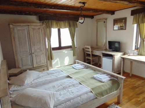 a bedroom with a bed and a desk in it at Arcso Fogado in Corund